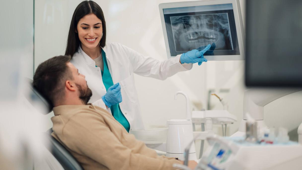 Orthodontist presenting a 3D treatment simulation to a patient during an orthodontic case presentation